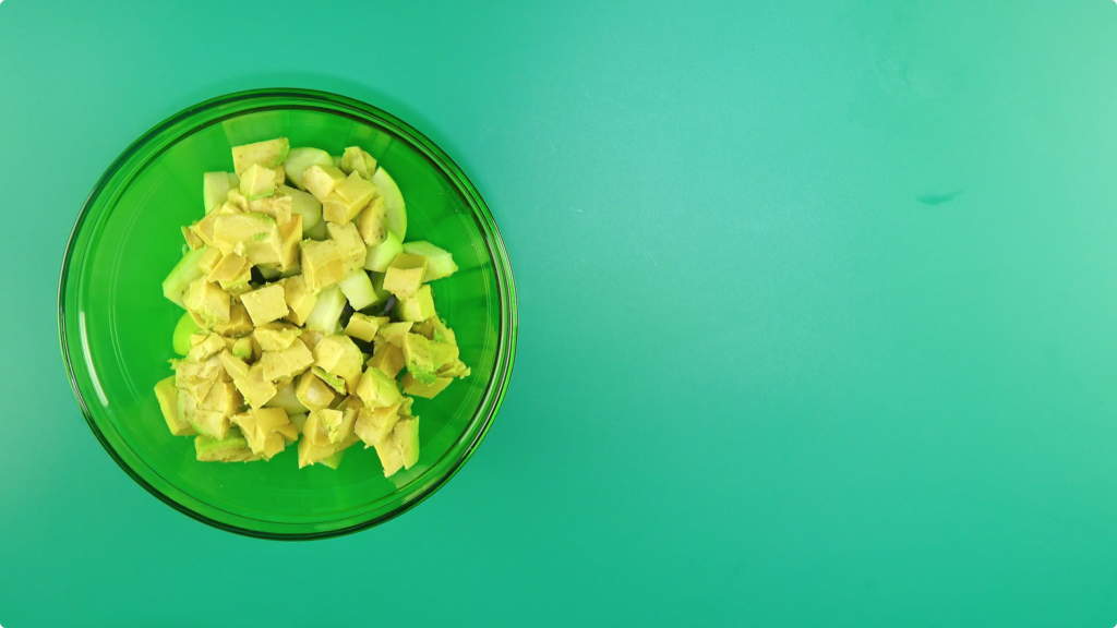 Diced avocado and apple in a glass bowl