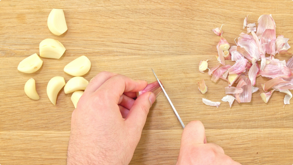 Preparing garlic cloves by peeling with knife