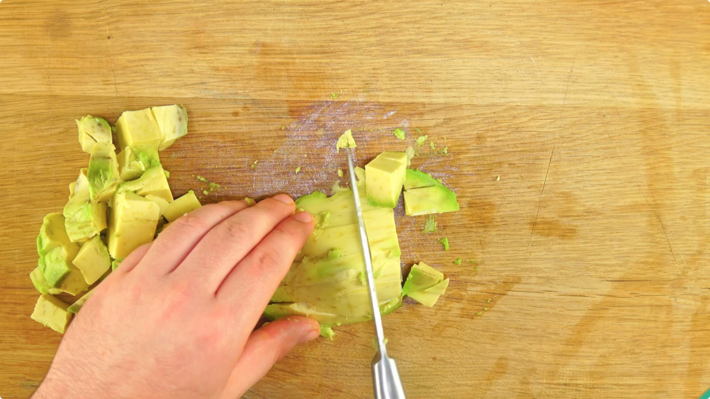 Chopping avocado on a wooden chopping board