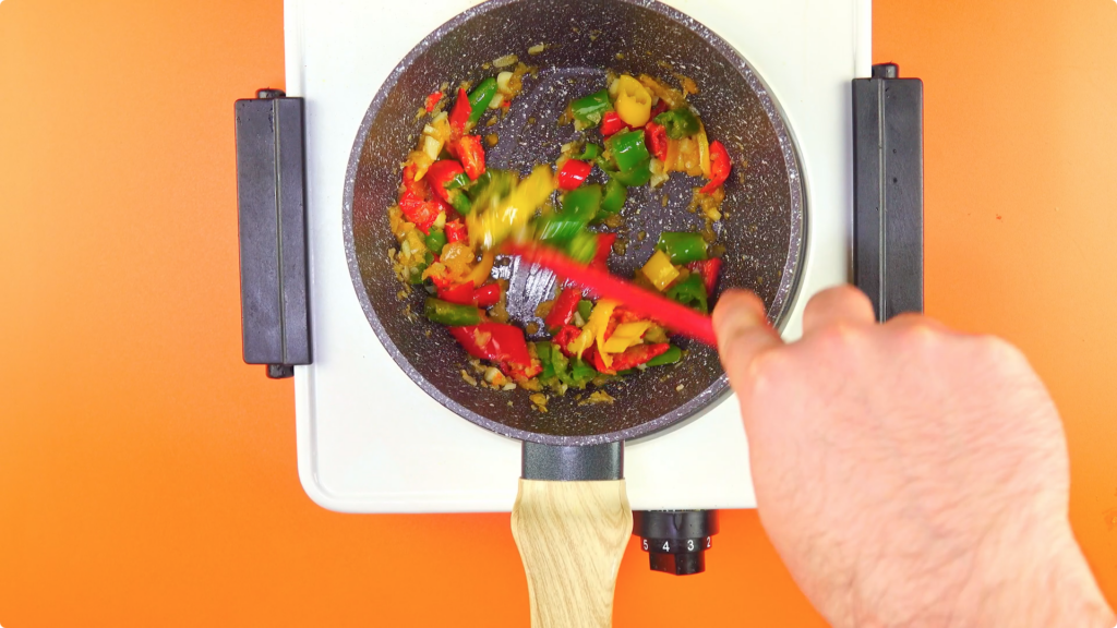 Cooking chillies with softened onions and garlic in a skillet