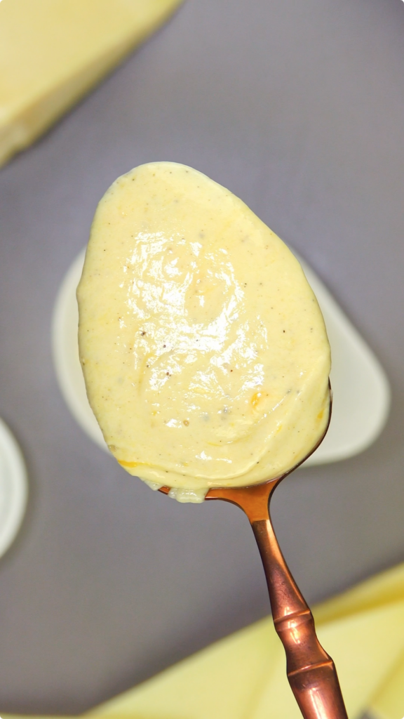 Close up spoon of easy chese sauce on a bronze spoon with out of focus background