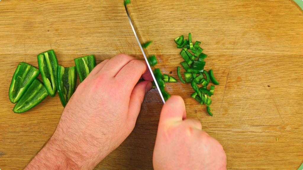 Chopped jalapeno green chillies on a wooden chopping board