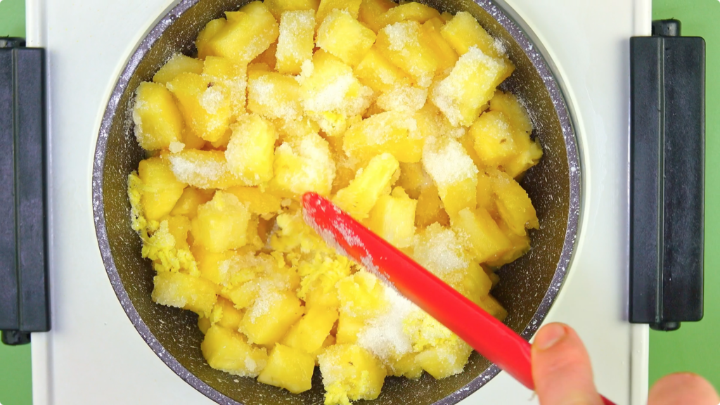 Stirring pineapple, sugar, salt and ginger together in a pan
