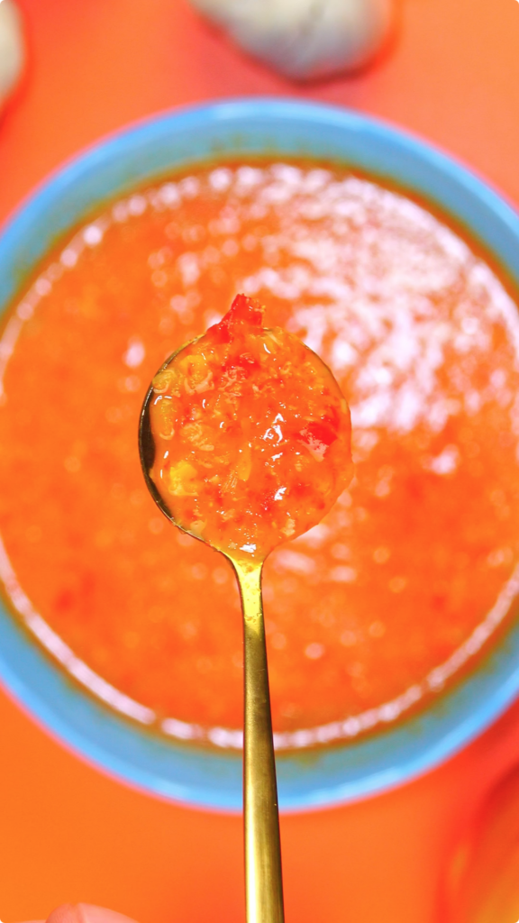 Spoonful of chunky hot sauce in focus with blurred background