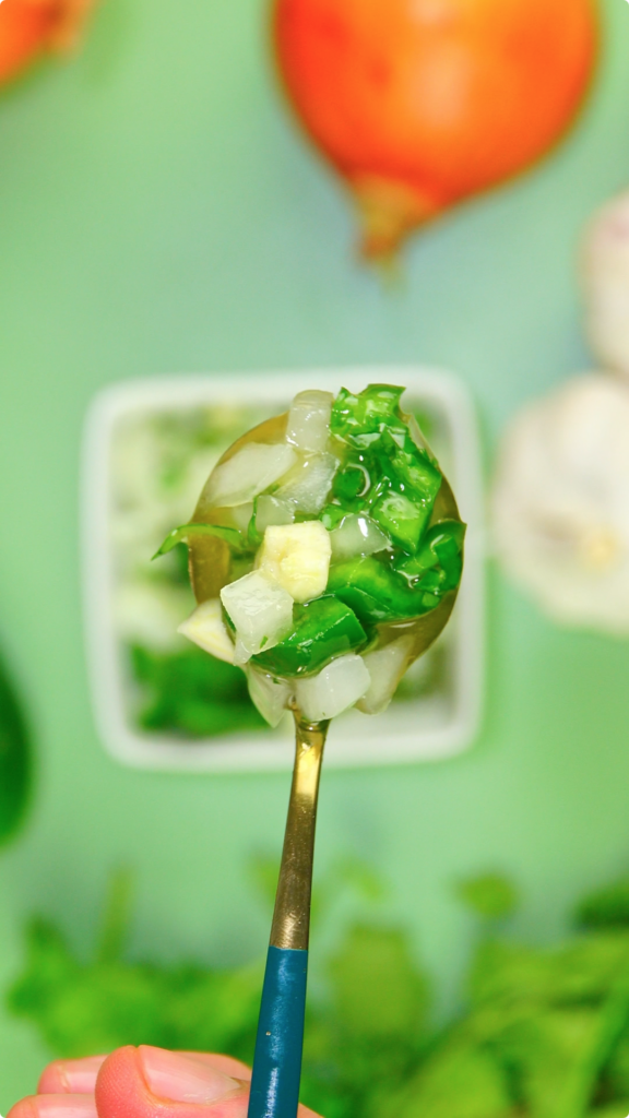 A spoonful of jalapeno and onion salsa up close with an out of focus background