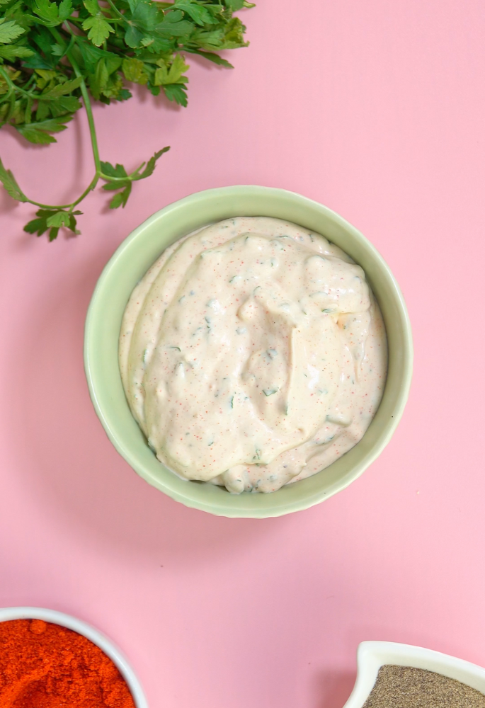 Finished tabasco and cream cheese dip in a bowl on a pink background