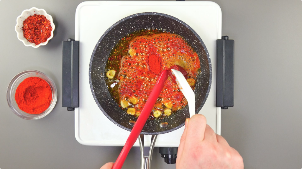 Stirring paprika and tomato paste into Pil Pil sauce