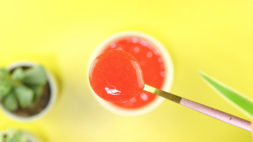 Spoonful of strawberry coulis with out of focus background