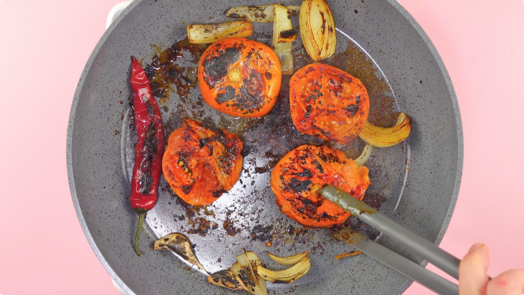 Charring tomatoes, chillies and onion in a dry skillet