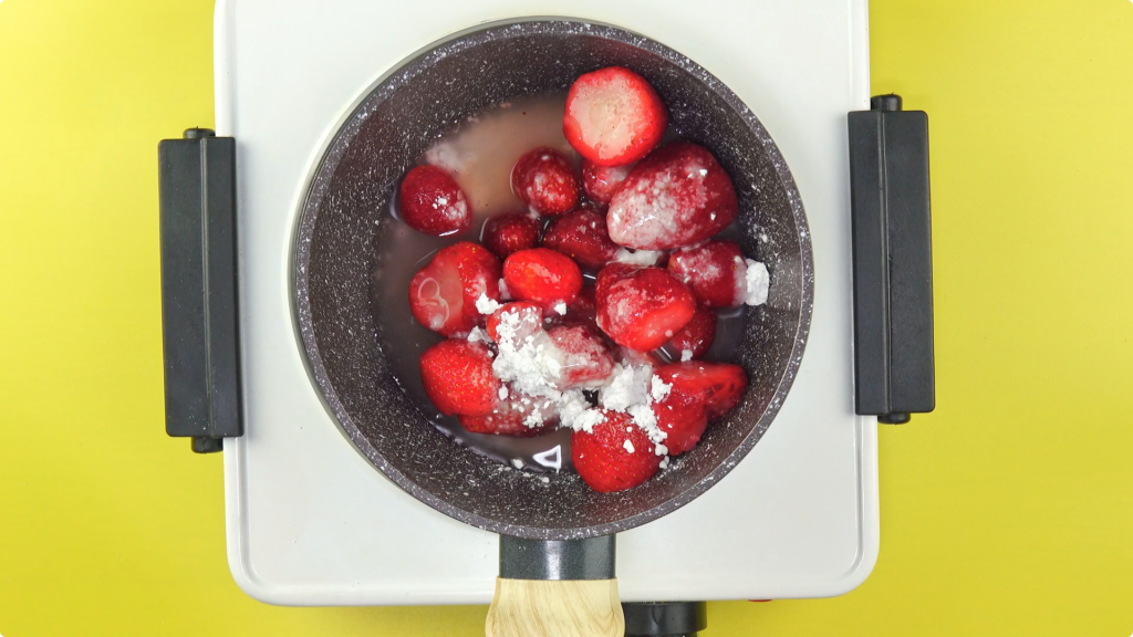 Combining strawberries, sugar, water and lemon juice in a pan over a hob